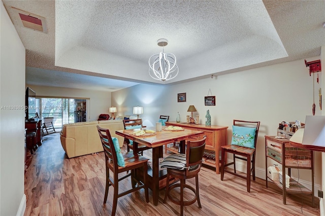 23344 Carolwood Ln Unit 303, Boca Raton, FL 33428 - dining space with a textured ceiling, light wood finished floors, a chandelier, and a raised ceiling