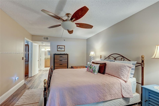 23344 Carolwood Ln Unit 303, Boca Raton, FL 33428 - bedroom featuring wood finished floors, a textured ceiling, a ceiling fan, and ensuite bath