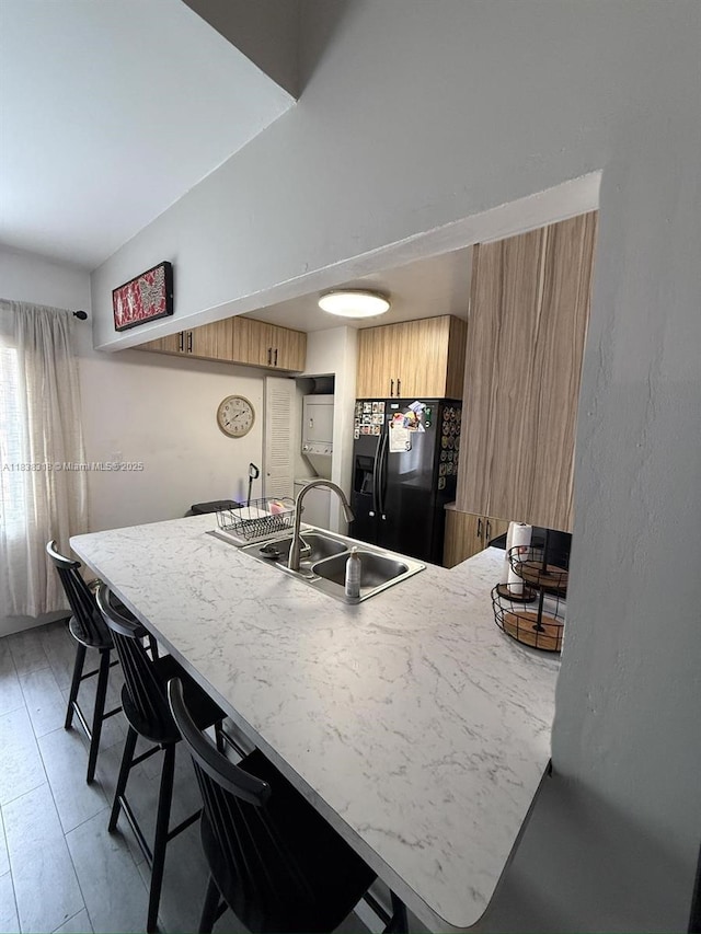 575 W Park Dr Unit 202, Miami, FL 33172 - kitchen featuring black refrigerator with ice dispenser, a peninsula, brown cabinets, a kitchen breakfast bar, and modern cabinets