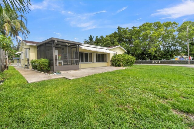 1900 N 31st Ave, Hollywood, FL 33021 - back of house featuring a sunroom, a patio, and stucco siding