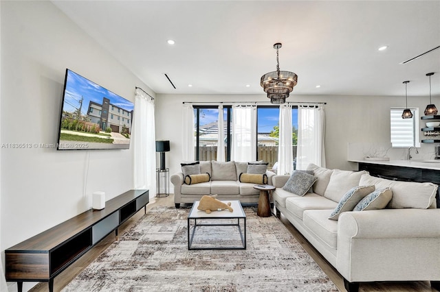 1617 NE 11th St Unit 1, Fort Lauderdale, FL 33304 - living room featuring wood finished floors, recessed lighting, and a chandelier
