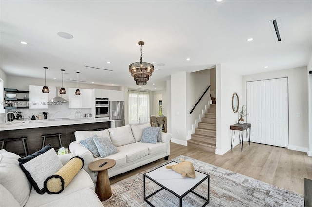 1617 NE 11th St Unit 1, Fort Lauderdale, FL 33304 - living room with stairs, recessed lighting, light wood-style flooring, and a chandelier