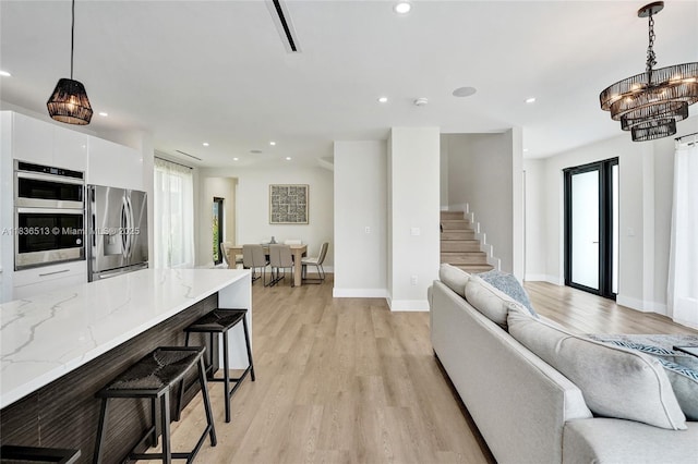 1617 NE 11th St Unit 1, Fort Lauderdale, FL 33304 - living room featuring light wood-style floors, a chandelier, recessed lighting, and stairway