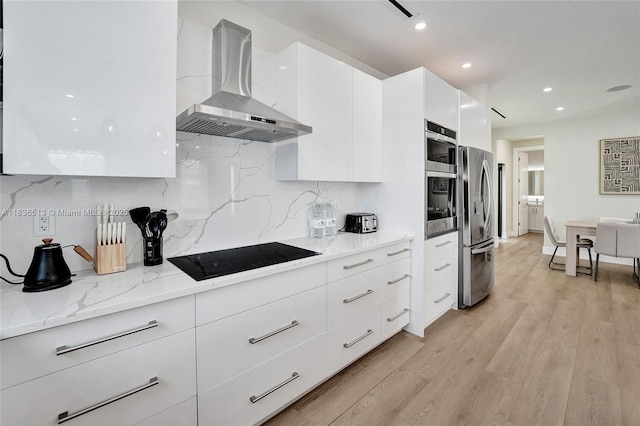 1617 NE 11th St Unit 1, Fort Lauderdale, FL 33304 - kitchen with wall chimney range hood, stainless steel appliances, modern cabinets, white cabinetry, and decorative backsplash