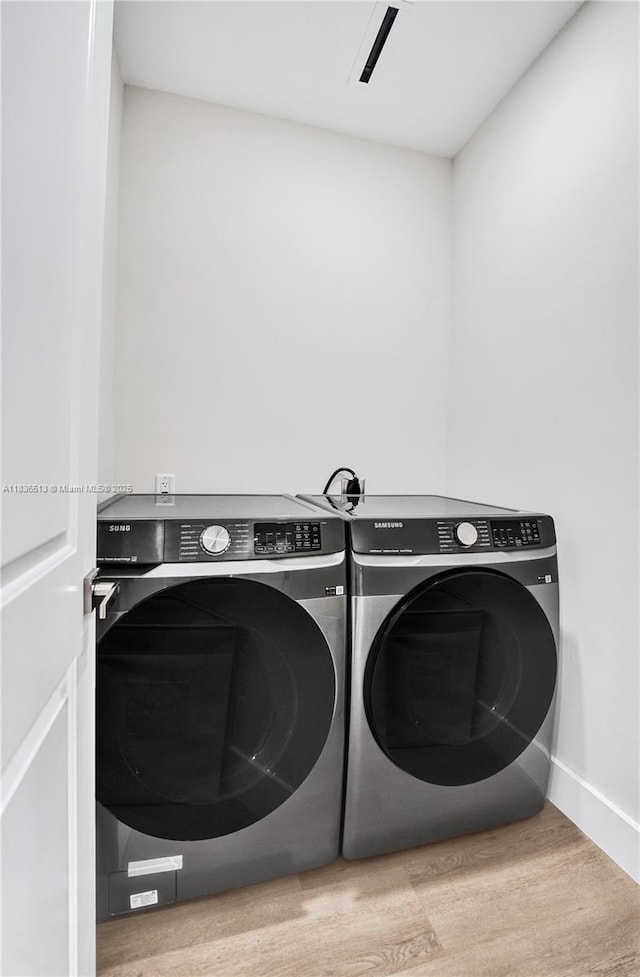 1617 NE 11th St Unit 1, Fort Lauderdale, FL 33304 - washroom featuring washer and clothes dryer and wood finished floors