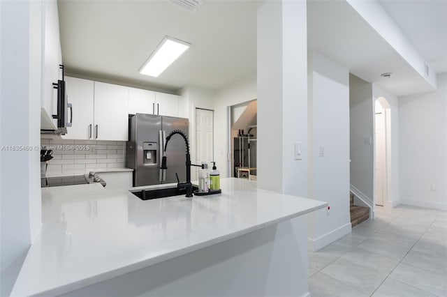 724 SW 106th Ave Unit 2010, Pembroke Pines, FL 33025 - kitchen with stainless steel fridge with ice dispenser, backsplash, a peninsula, light countertops, and white cabinetry
