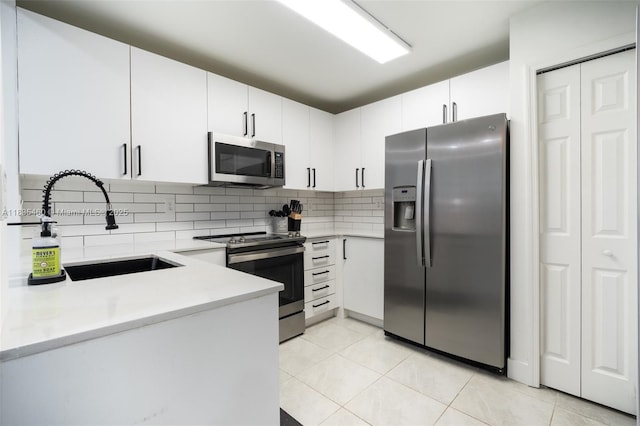 724 SW 106th Ave Unit 2010, Pembroke Pines, FL 33025 - kitchen with stainless steel appliances, light countertops, backsplash, light tile patterned floors, and white cabinets