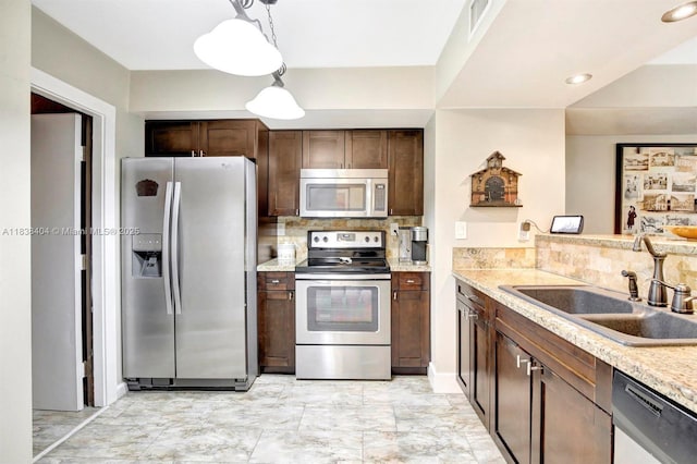 9715 NW 23rd Ct, Pembroke Pines, FL 33024 - kitchen featuring appliances with stainless steel finishes, backsplash, dark brown cabinets, pendant lighting, and recessed lighting