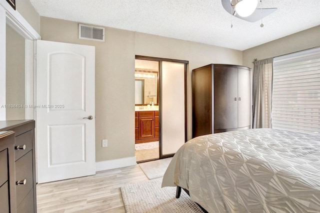9715 NW 23rd Ct, Pembroke Pines, FL 33024 - bedroom featuring light wood-style floors, a textured ceiling, ceiling fan, and ensuite bathroom