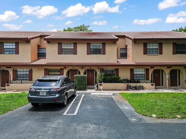 10942 W Sample Rd Unit E1, Coral Springs, FL 33065 - view of front facade with a tiled roof, stucco siding, and uncovered parking