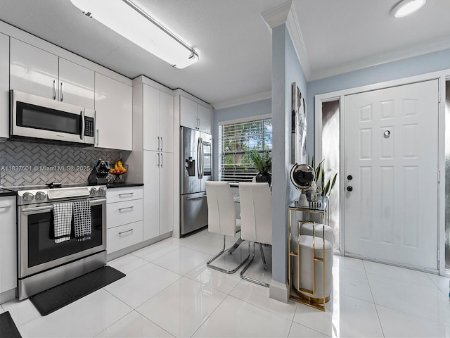 10942 W Sample Rd Unit E1, Coral Springs, FL 33065 - kitchen featuring stainless steel appliances, ornamental molding, dark countertops, decorative backsplash, and white cabinetry