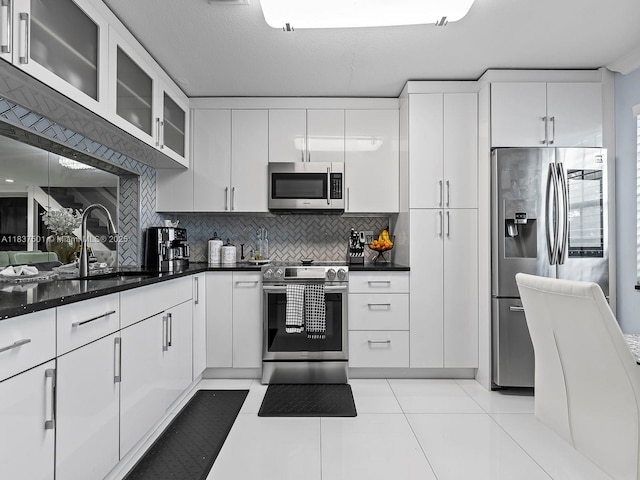10942 W Sample Rd Unit E1, Coral Springs, FL 33065 - kitchen featuring appliances with stainless steel finishes, decorative backsplash, white cabinets, glass insert cabinets, and light tile patterned flooring