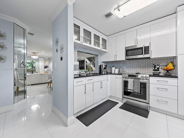 10942 W Sample Rd Unit E1, Coral Springs, FL 33065 - kitchen with appliances with stainless steel finishes, dark countertops, backsplash, and glass insert cabinets