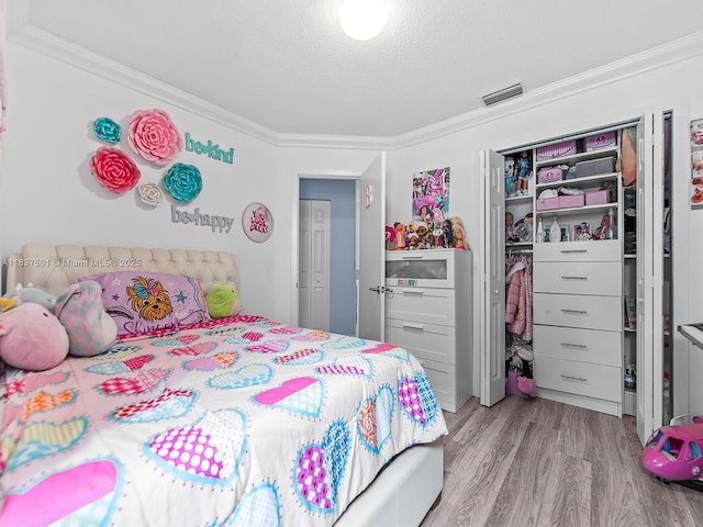 10942 W Sample Rd Unit E1, Coral Springs, FL 33065 - bedroom featuring ornamental molding, wood finished floors, a closet, and a textured ceiling