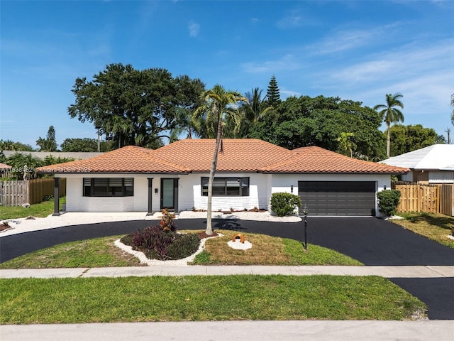 220 SW 75th Ter, Plantation, FL 33317 - view of front of home featuring asphalt driveway, an attached garage, stucco siding, and a tiled roof