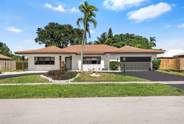 220 SW 75th Ter, Plantation, FL 33317 - mediterranean / spanish-style home with asphalt driveway, stucco siding, a tiled roof, and an attached garage