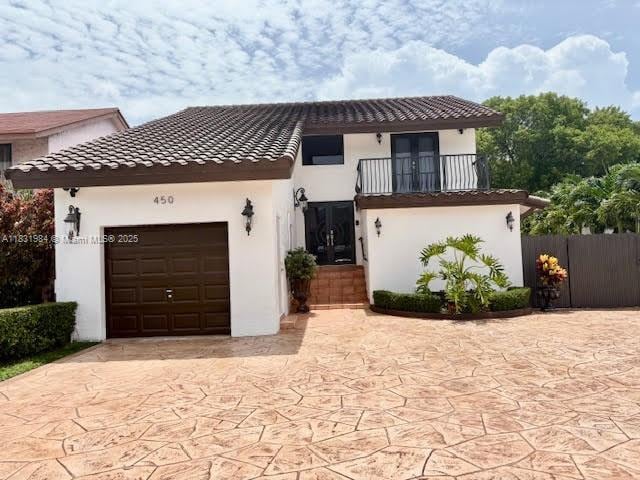 450 SW 89th Ct, Miami, FL 33174 - view of front of home with french doors, a balcony, a garage, and a tile roof