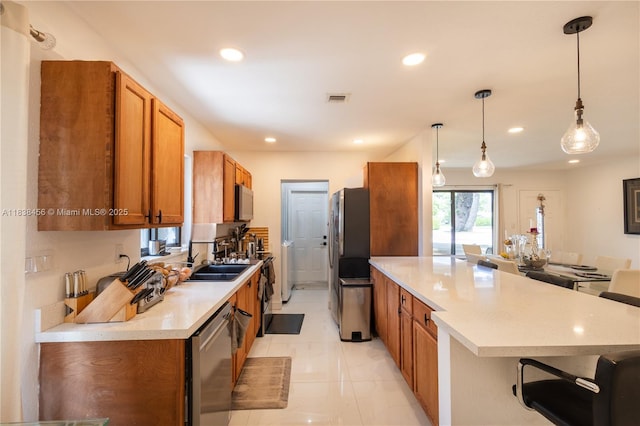 2841 NW 9th Ave, Wilton Manors, FL 33311 - kitchen with stainless steel appliances, brown cabinetry, a peninsula, recessed lighting, and light countertops