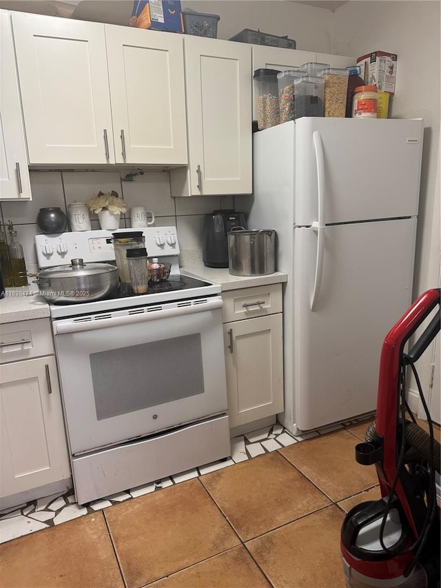 3610 NW 21st St Unit 413, Lauderdale Lakes, FL 33311 - kitchen with white appliances, light countertops, light tile patterned flooring, and white cabinets