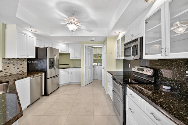 5938 Crystal Shores Dr Unit 103, Boynton Beach, FL 33437 - kitchen with stainless steel appliances, washing machine and clothes dryer, white cabinets, light tile patterned floors, and tasteful backsplash