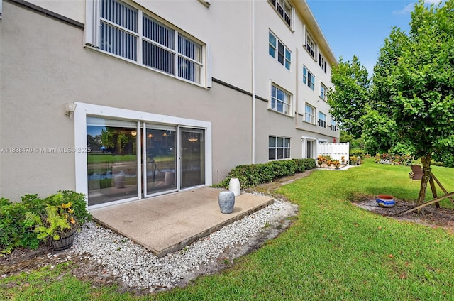 5938 Crystal Shores Dr Unit 103, Boynton Beach, FL 33437 - back of property featuring a yard, stucco siding, and a patio