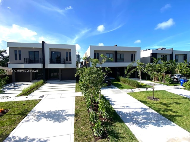 313 SW 10th St Unit A, Fort Lauderdale, FL 33315 - view of front facade featuring stucco siding, a garage, a balcony, and driveway