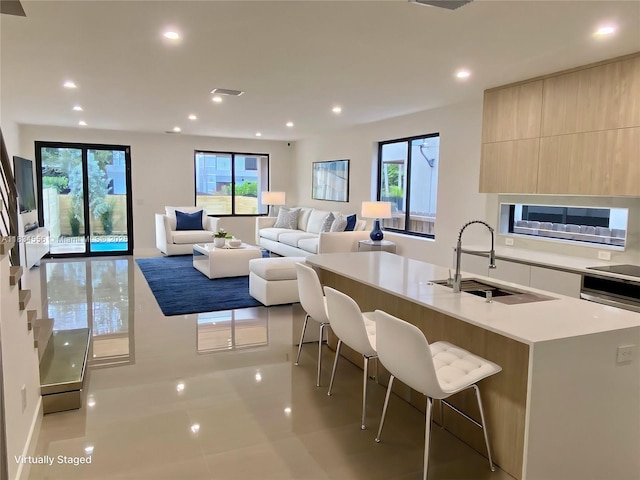 313 SW 10th St Unit A, Fort Lauderdale, FL 33315 - kitchen featuring modern cabinets, a kitchen island with sink, recessed lighting, light countertops, and a kitchen bar