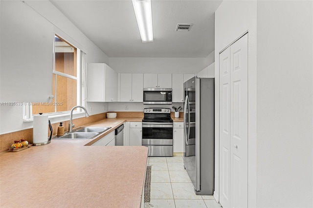 771 SE 2nd St, Homestead, FL 33030 - kitchen featuring stainless steel appliances, light countertops, and white cabinets
