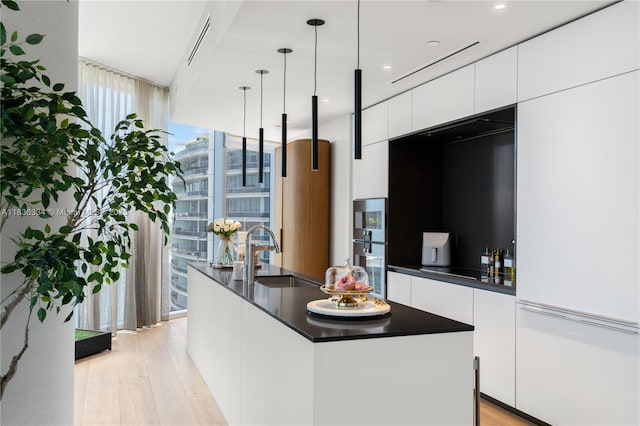 300 Biscayne Blvd Way Unit 4707, Miami, FL 33131 - kitchen with modern cabinets, dark countertops, light wood-style flooring, white cabinets, and expansive windows