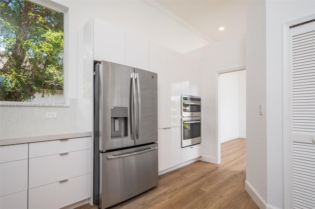 2664 Edgewater Dr, Weston, FL 33332 - kitchen featuring stainless steel appliances, modern cabinets, white cabinets, light wood-type flooring, and light countertops