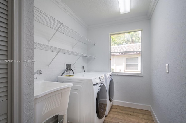 2664 Edgewater Dr, Weston, FL 33332 - washroom featuring ornamental molding, separate washer and dryer, light wood finished floors, and a textured wall