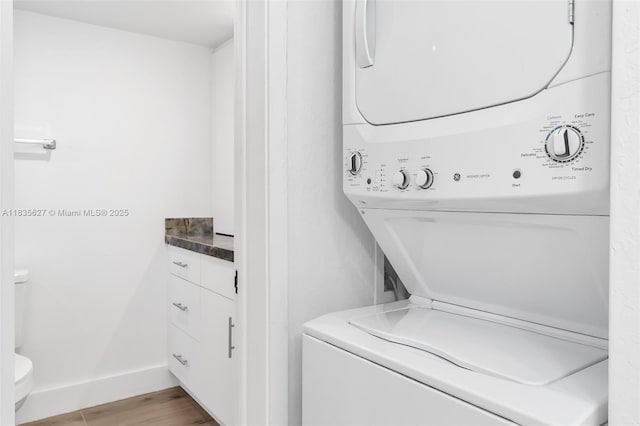 7304 SW 82nd St Unit A107, Miami, FL 33143 - washroom featuring stacked washer and clothes dryer and wood finished floors