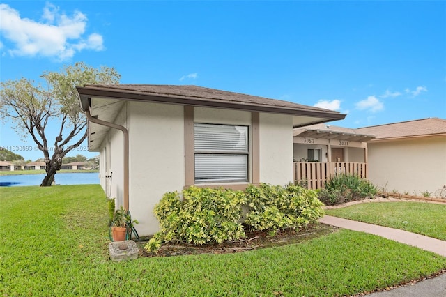 3057 NW 109th Ave Unit 3057, Sunrise, FL 33322 - view of property exterior featuring a lawn, stucco siding, and a water view