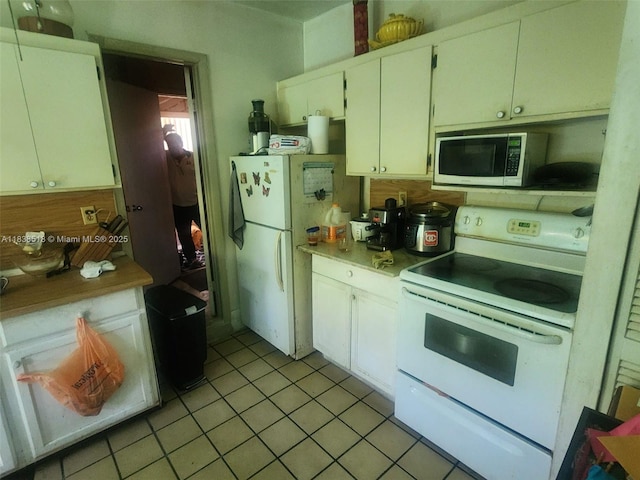 935 SW 72nd Ave, Miami, FL 33144 - kitchen featuring white appliances, light tile patterned floors, light countertops, and white cabinetry