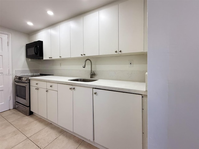8650 SW 109th Ave Unit 3-112, Miami, FL 33173 - kitchen with black microwave, stainless steel range with electric cooktop, light countertops, white cabinets, and recessed lighting
