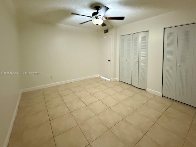 8650 SW 109th Ave Unit 3-112, Miami, FL 33173 - unfurnished bedroom with multiple closets, a textured ceiling, light tile patterned floors, and ceiling fan