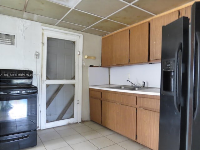 525 NW 16th St, Pompano Beach, FL 33060 - kitchen featuring black appliances, light countertops, light tile patterned flooring, and brown cabinetry