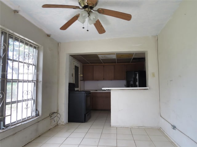 525 NW 16th St, Pompano Beach, FL 33060 - kitchen with black appliances, a ceiling fan, light tile patterned floors, brown cabinets, and a peninsula