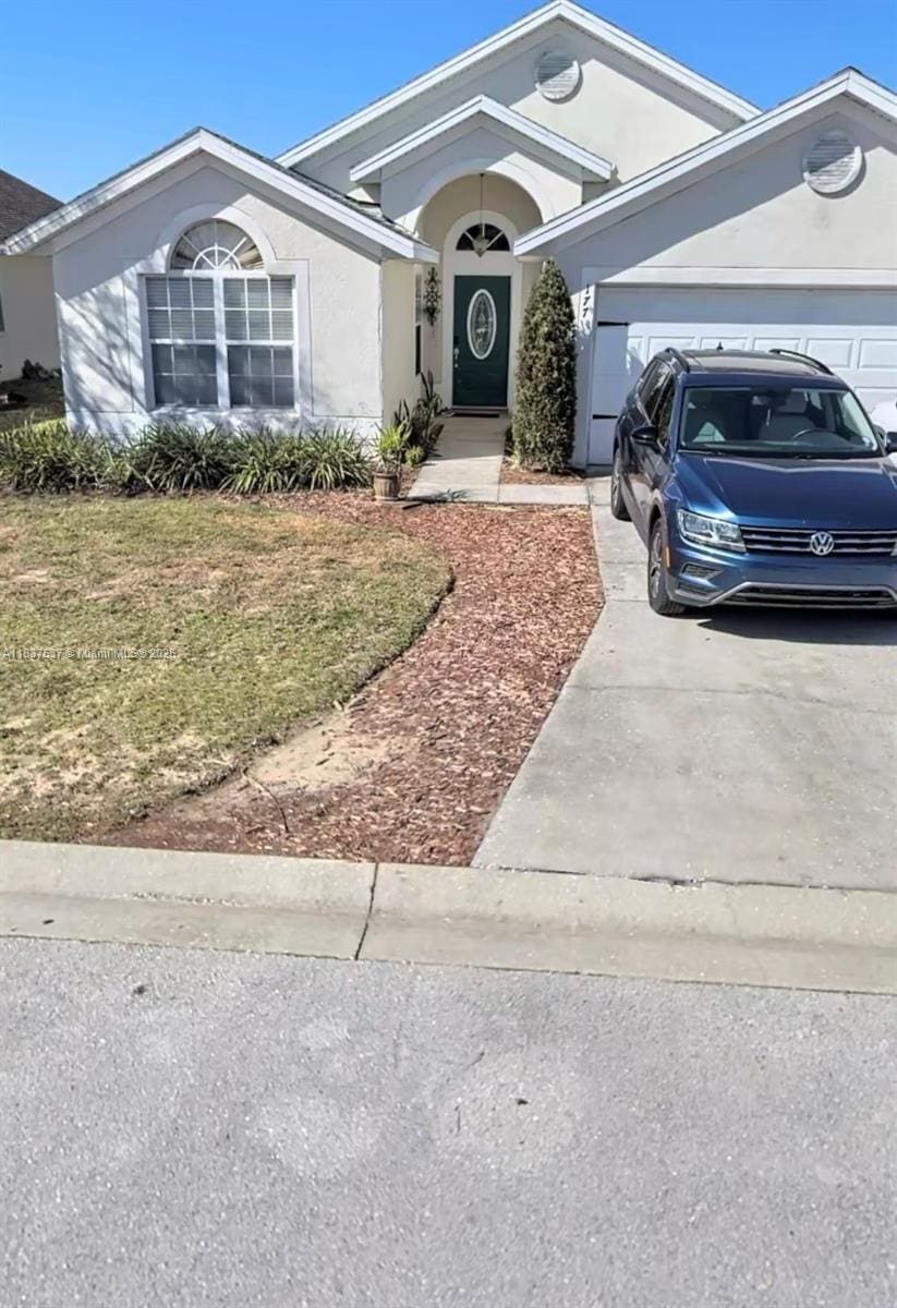 177 Heather Lynn, Davenport, FL 33897 - ranch-style house with concrete driveway, an attached garage, stucco siding, and a front yard