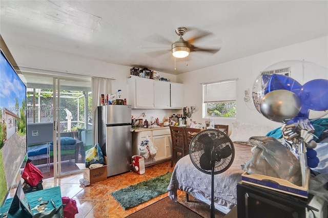 6768 Rose Dr, Miramar, FL 33023 - kitchen featuring freestanding refrigerator, a ceiling fan, light tile patterned floors, white cabinets, and light countertops