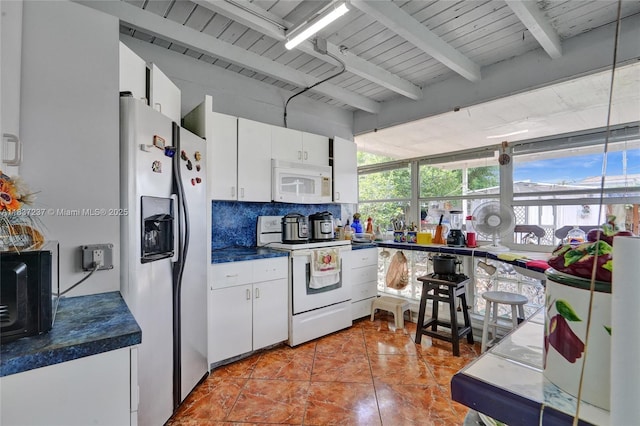 6768 Rose Dr, Miramar, FL 33023 - kitchen featuring white appliances, beamed ceiling, tasteful backsplash, dark countertops, and white cabinets