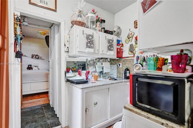6768 Rose Dr, Miramar, FL 33023 - kitchen featuring black microwave, light countertops, white cabinetry, and tasteful backsplash