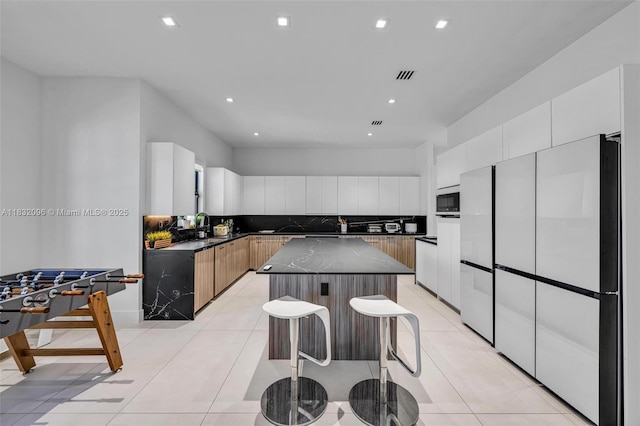 4541 SW 174th Ave, Miramar, FL 33029 - kitchen with freestanding refrigerator, backsplash, built in microwave, a center island, and recessed lighting