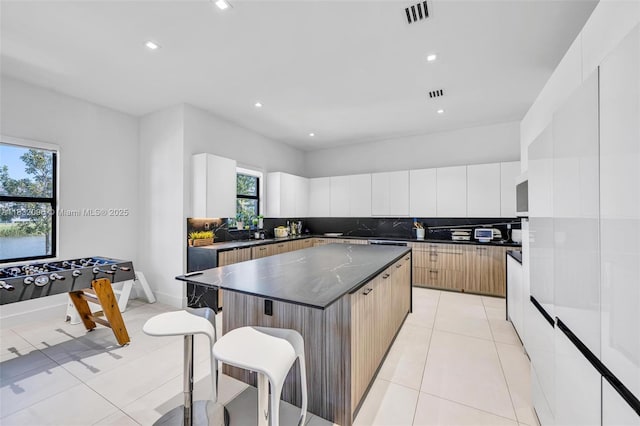 4541 SW 174th Ave, Miramar, FL 33029 - kitchen featuring a breakfast bar, modern cabinets, a kitchen island, tasteful backsplash, and light tile patterned floors