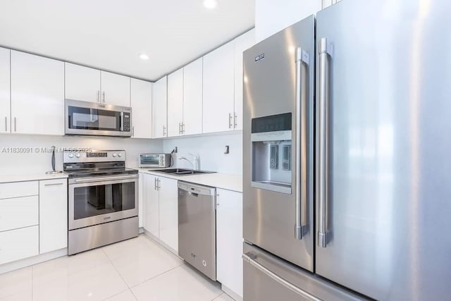 19370 Collins Ave Unit 607, Sunny Isles Beach, FL 33160 - kitchen with appliances with stainless steel finishes, light countertops, white cabinets, light tile patterned flooring, and recessed lighting