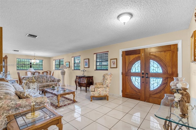 13325 SW 32nd St, Miami, FL 33175 - foyer entrance featuring a chandelier, french doors, a textured ceiling, and light tile patterned flooring