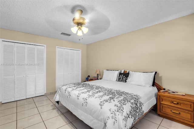 13325 SW 32nd St, Miami, FL 33175 - bedroom with two closets, light tile patterned floors, ceiling fan, and a textured ceiling