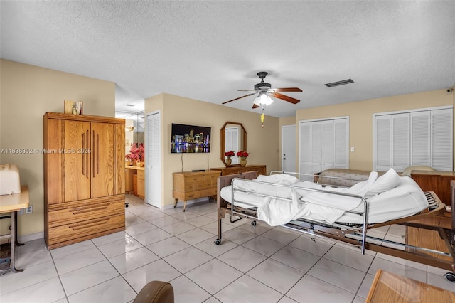 13325 SW 32nd St, Miami, FL 33175 - bedroom featuring two closets, a textured ceiling, light tile patterned floors, and a ceiling fan
