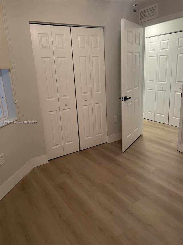 11605 NW 89th St Unit 112, Doral, FL 33178 - unfurnished bedroom featuring light wood-style floors and a closet