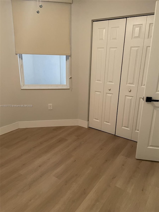 11605 NW 89th St Unit 112, Doral, FL 33178 - unfurnished bedroom with light wood-style floors and a closet
